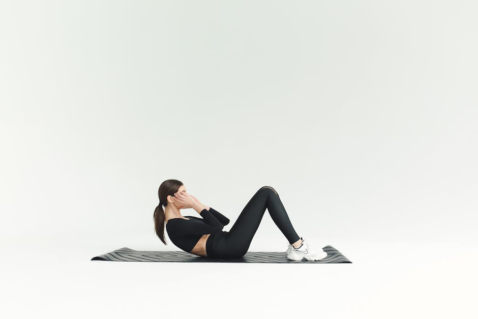 Image depicting someone performing sit-ups on a yoga mat.