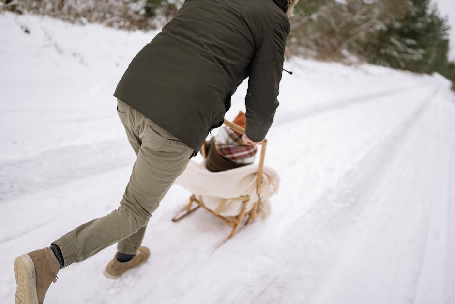 Image description: A person pushing a sled with determination on a grass field